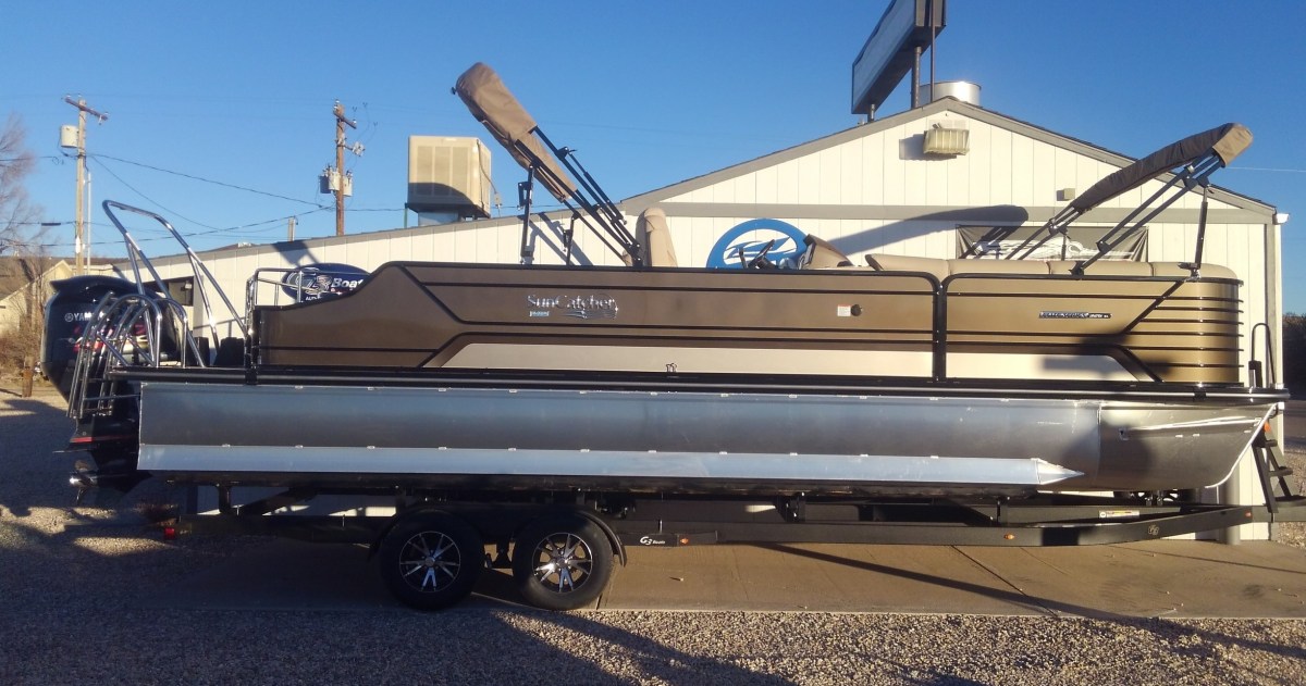1. 26′ 2021 G3 Elite 326SL Tritoon (Cruise/Play/Tow) Image 1 a truck is parked in a parking lot